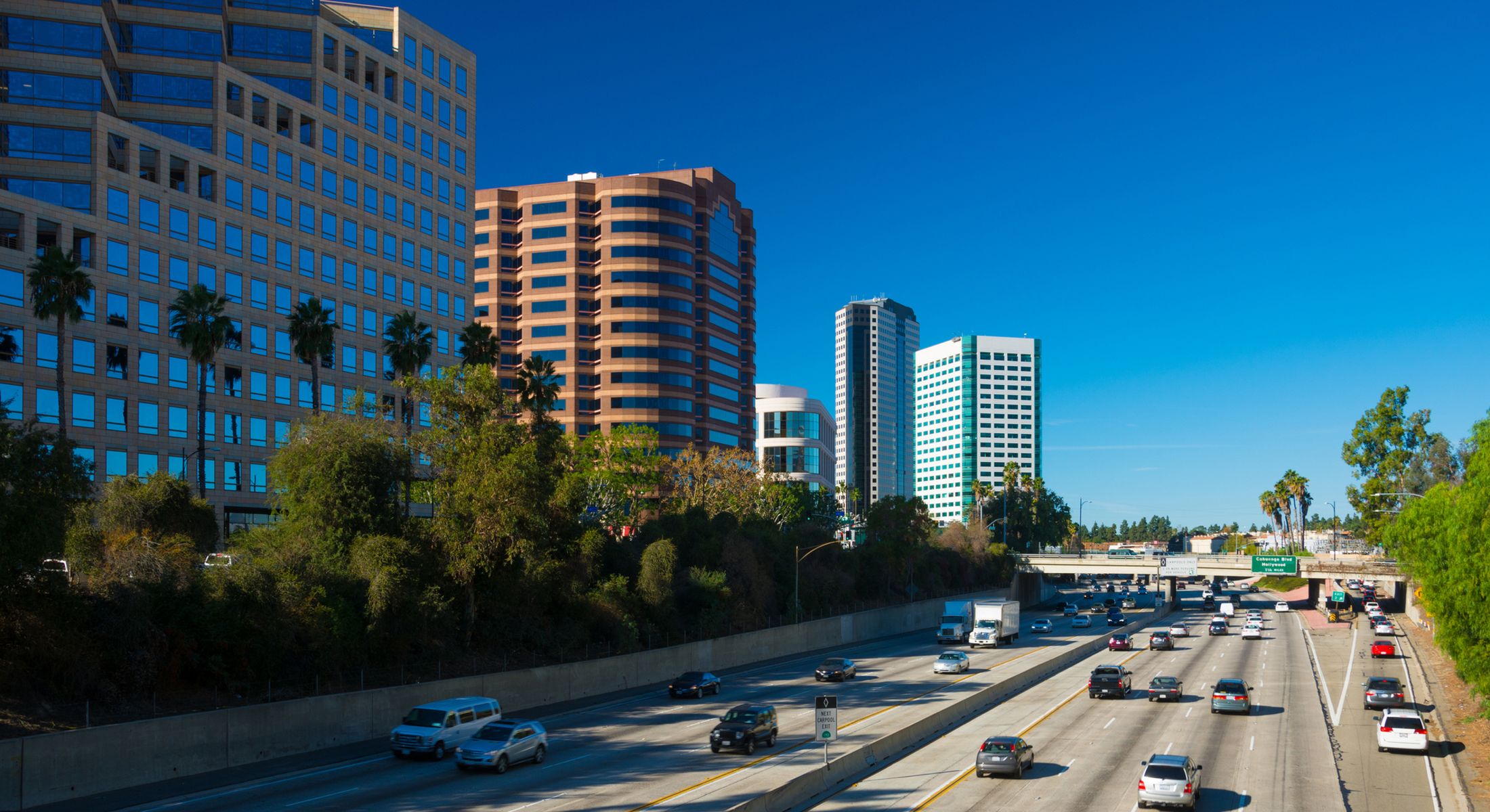 Urban skyline alongside busy freeway in sunny California.